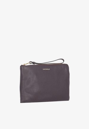 Donkerbruine leren polsclutch met gouden ritssluiting en een klein lusje als handvat, voorzien van het merk "Coccinelle" in gouden letters aan de voorkant.