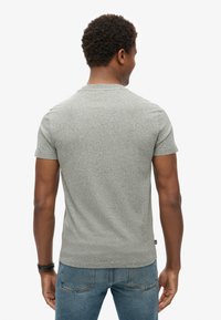 Grijze t-shirt met korte mouwen in een gestructureerde stof, met een ronde halslijn en een licht getailleerde pasvorm, gezien vanaf de achterkant.