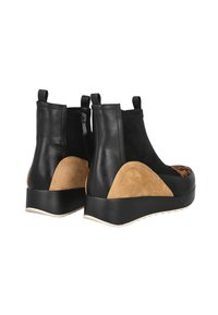 Botas de tobillo de cuero negro con detalles en ante marrón, de forma elegante y con un tacón escondido. Cuentan con una cremallera lateral para facilitar su uso.