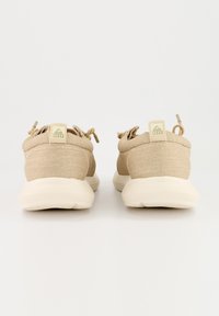 Beige Sportchuhe mit einem strukturierten Obermaterial aus Stoff und einer hellen Gummisohle. Enthält verstellbare Schnürsenkel und ein Logobranding auf der Rückseite.