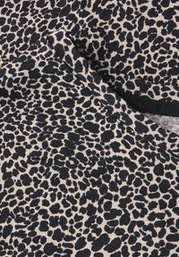 Tessuto maculato leopardato in beige con macchie blu scuro; texture liscia con un motivo a colori contrastanti; con un bordo piegato.