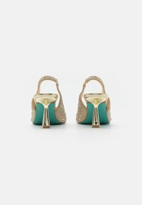 Décolleté con tacco slingback ricamate in oro con una piattaforma turchese e un accento in metallo sul tacco. Superficie texturizzata con decorazioni.