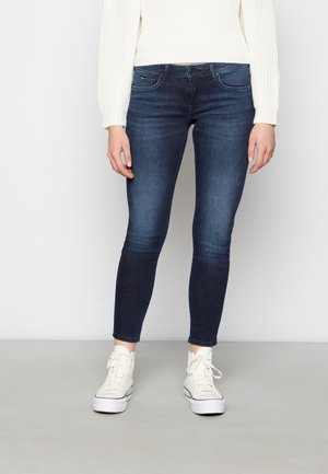 Jeans ajustados en denim azul oscuro, con un diseño clásico de cinco bolsillos, cierre frontal de botón y un ligero estiramiento para mayor comodidad.