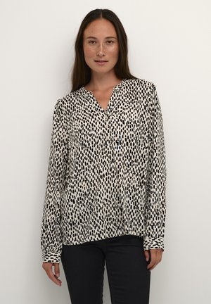 Lange mouwen blouse in crèmekleur met een zwart abstract vlekkenpatroon, voorzien van een knoopsluiting aan de voorkant en een kraag, gemaakt van lichtgewicht stof.