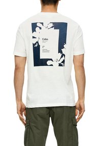 Biała bawełniana koszulka z okrągłym dekoltem i krótkim rękawem, z granatowym prostokątnym wzorem na plecach, ozdobionym kwiatowymi akcentami oraz nadrukowanym tekstem.