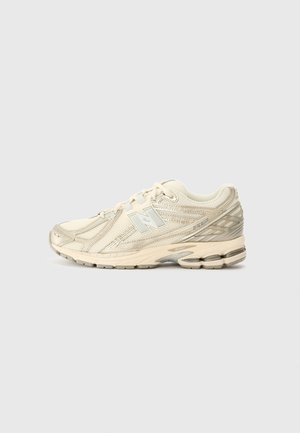 Beiger New Balance Laufschuh mit Mesh- und synthetischem Obermaterial, gedämpfter Sohle und "N" Logo an der Seite, von der Außenseite gezeigt.