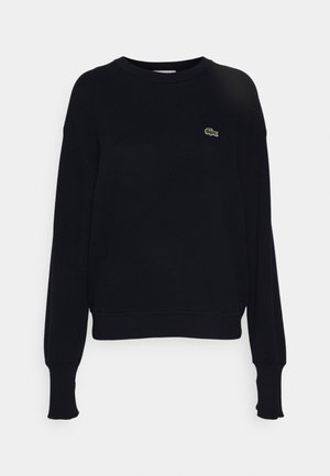 Czarny polarowy sweter wykonany z mieszanki bawełny, z długimi rękawami, okrągłym dekoltem i małym zielonym logo na tle. Żebrowane mankiety i dół.
