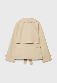 Trench-coat beige raccourci à manches longues, détail yoke au dos, large col et deux extrémités de ceinture en tissu pendantes sur un fond clair.