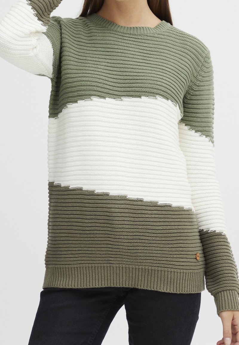 Stickad tröja med olivgröna och vita horisontella ränder. Ribbad ärm- och nederkant, med en liten logotagg på den nedre sidan.