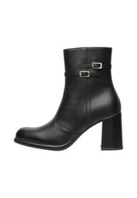 Bottines en cuir noir avec un talon bloc haut, dotées de deux sangles ajustables avec boucles en or et d'une finition lisse et brillante.