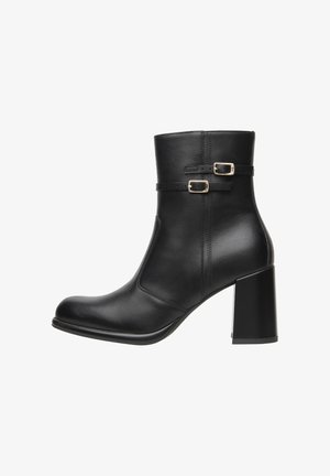 Černá kožená kotníková bota s vysokým blokovým podpatkem, vybavená dvojicí nastavitelných popruhů se zlatými sponami a hladkým, lesklým povrchem.