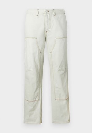 Pantalons cargo beige clair en coton, dotés de plusieurs poches, de coutures contrastantes et d'une coupe droite. Texture de tissu durable.