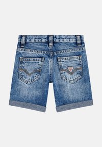 Pantalones cortos de mezclilla en azul claro con puños doblados, bolsillos traseros con un diseño cosido y un pequeño parche de logo. Estilo clásico de cinco bolsillos.