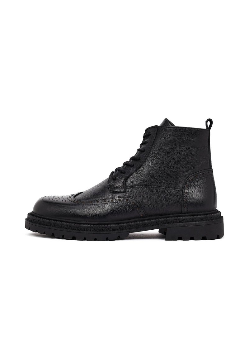 Zwarte leren enkellaarsjes met een gestructureerde afwerking, voorzien van brogue-details en een robuuste rubberen zool voor betere grip. Vetersluiting.