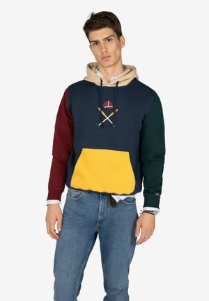 Felpa color block con sezioni in navy, bordeaux, verde e giallo. Il materiale è morbido, con un design ricamato di remi incrociati.
