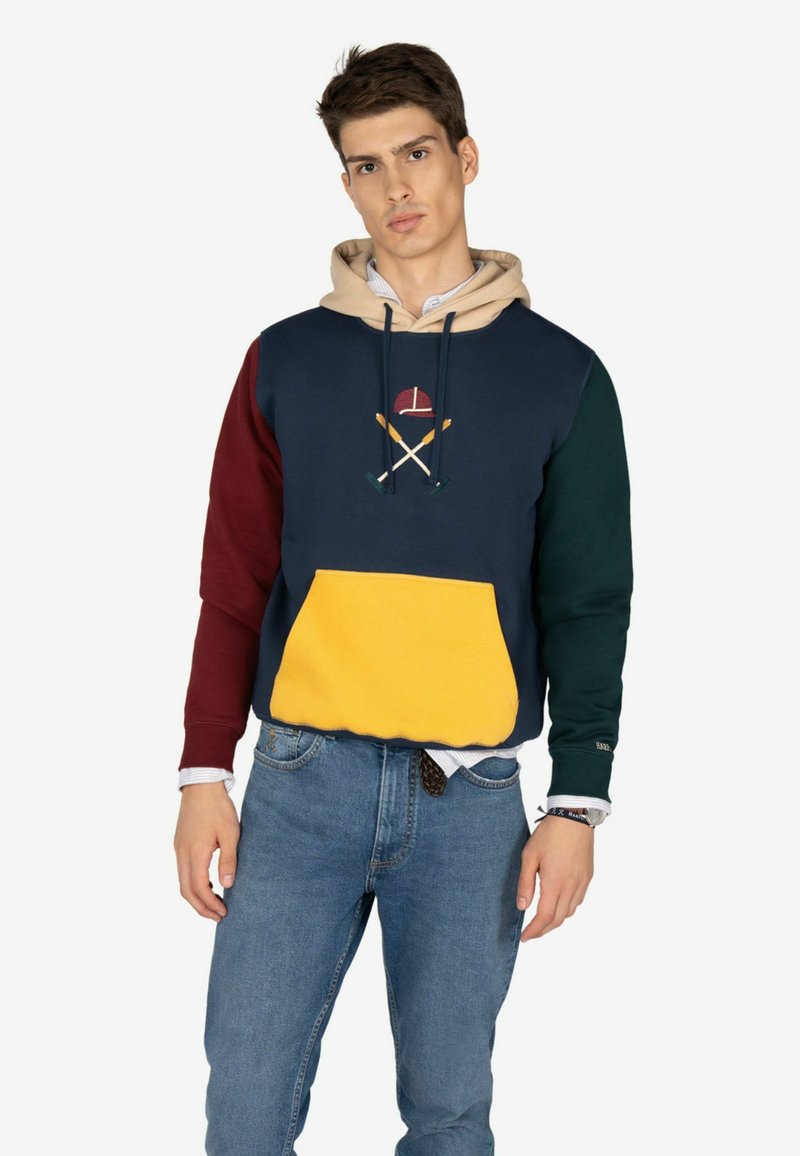 Felpa color block con sezioni in navy, bordeaux, verde e giallo. Il materiale è morbido, con un design ricamato di remi incrociati.