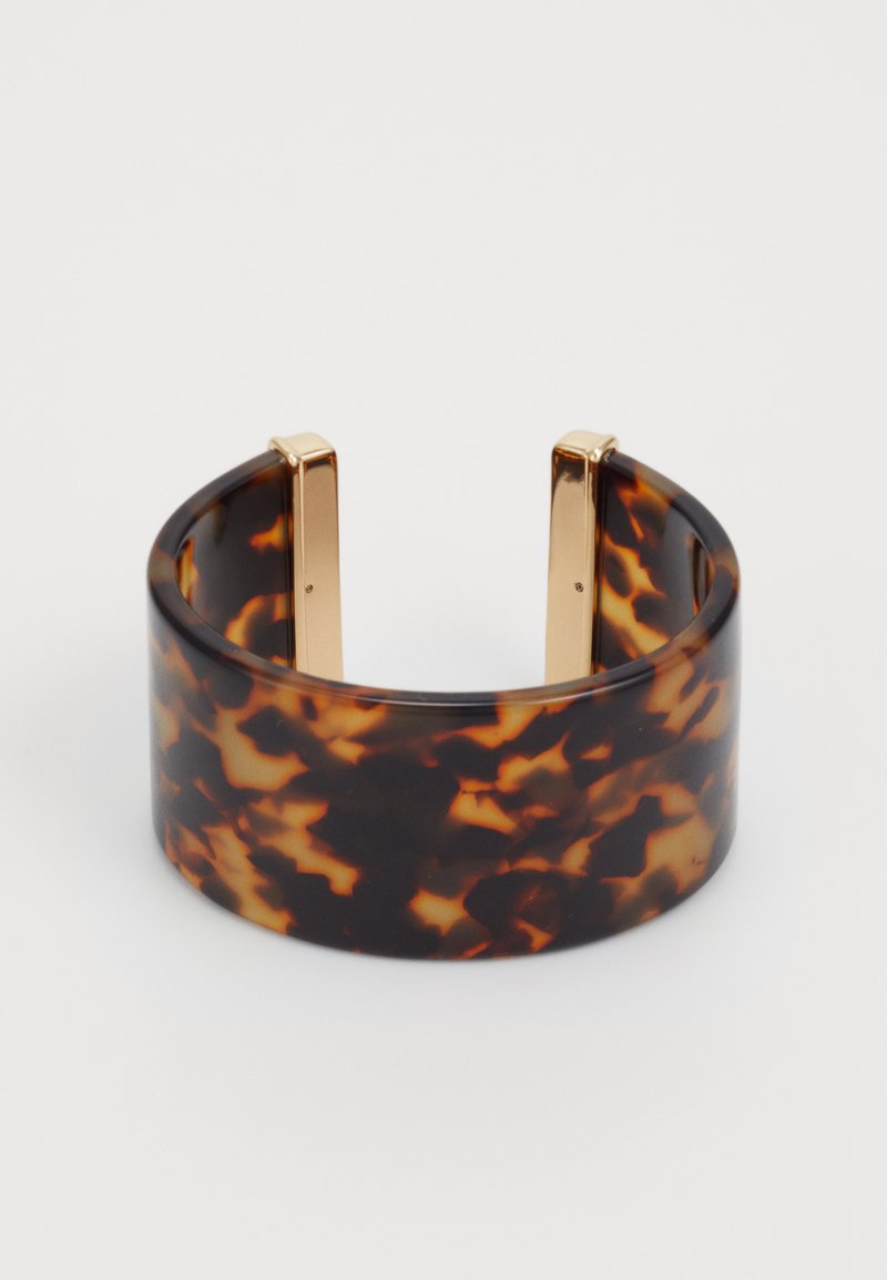 Brățară din acrilic cu model țestoasă, cu accente de metal aurit. Textură netedă, bandă lată, design cu spate deschis.