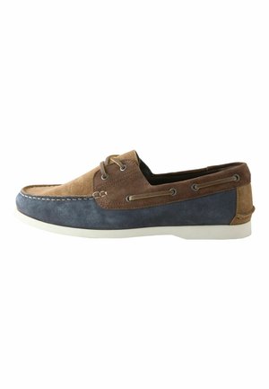 Men’s casual boat shoe in brown and navy suede with white sole and lace detail around the heel collar.