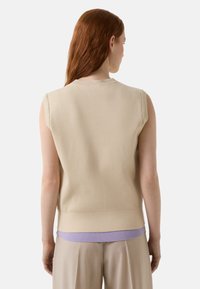 Beiges ärmelloses Oberteil mit einem gerippten Halsausschnitt und einem kontrastierenden, lavendelfarbenen, gerippten Saum, aus leichtem Strickmaterial mit glatter Textur.