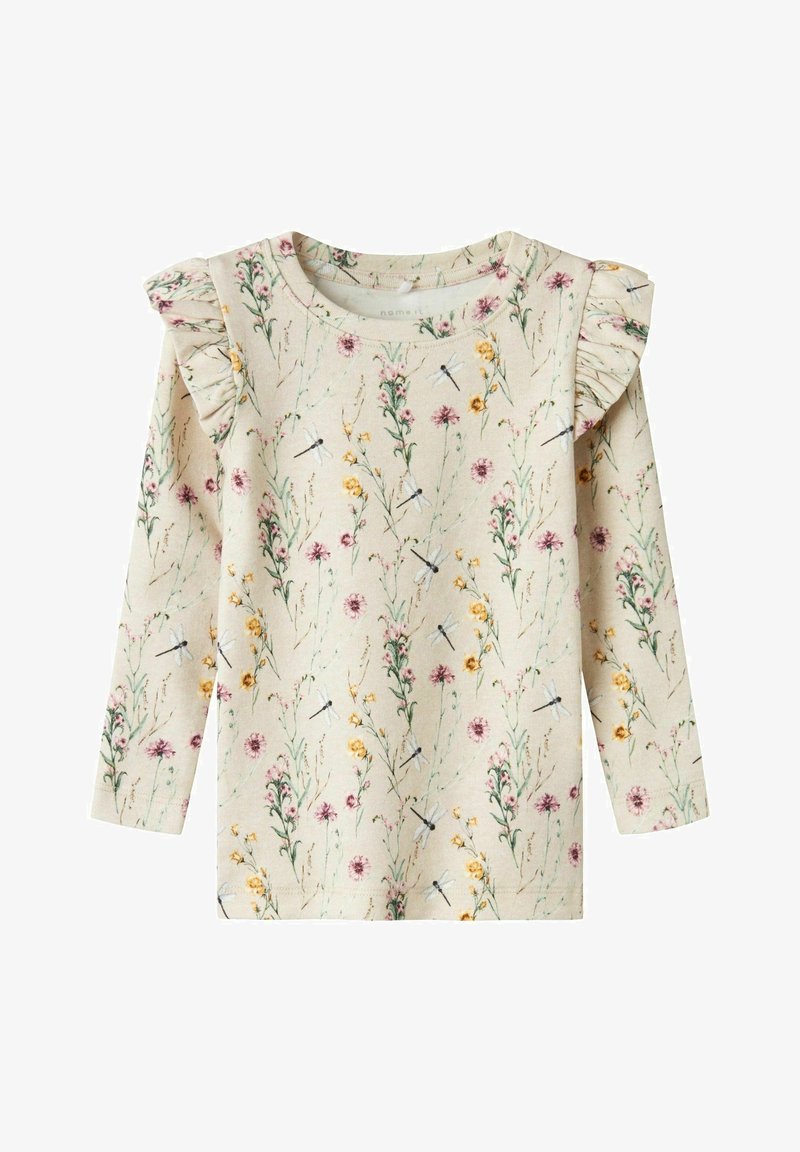 Chemise beige à manches longues avec des détails à volants aux épaules, décorée de fleurs sauvages roses et jaunes et de petites illustrations de libellules.