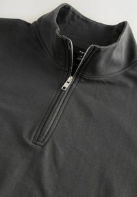 Tmavošedá bunda na zips vyrobená z mäkkej, hladkej tkaniny. Obsahuje vysoký golier a strieborný zips s ťahákom. Jednoduchý dizajn bez vzorov.