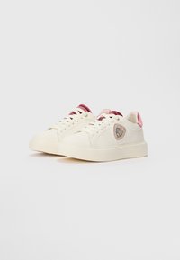 Baskets en toile blanche avec un bout rond, des accents rose et bordeaux sur la languette et le talon, et un patch de logo texturé sur le côté.