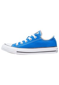 Blå canvas sneakers med vit gummitåkapsel och sula, svart rand och vita snören. Har en lågtoppdesign och kontrasterande sömmar.