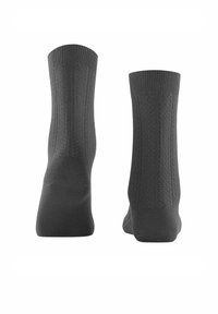 Chaussettes grises tricotées avec des poignets côtelés, présentant un motif texturé sur les côtés et une finition lisse. Façonnées pour épouser la forme du pied et assurer le confort.