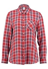 Chemise à carreaux rouges et noirs avec manches longues, col et une poche poitrine unique. Fabriquée en tissu tissé à motif à carreaux.