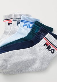 Fem par med crewsokker i forskjellige farger: grå, lyseblå, mørk teal, marineblå og hvit. Hver sokk har en ribbestrikket mansjett og "Fila"-logo.