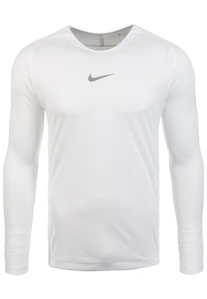 T-shirt de sport blanc à manches longues avec col rond et logo Nike swoosh gris centré sur la poitrine sur fond blanc.