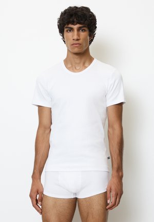 Weißes Baumwoll-T-Shirt mit kurzen Ärmeln, rundem Halsausschnitt und subtilem geripptem Muster, kombiniert mit nahtlosen weißen Slips.