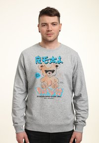 Sudadera gris con un gráfico de un oso de dibujos animados con gafas de sol, texto azul y letras en negrita. Material suave con puños acanalados.