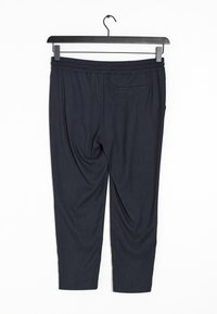 Pantalon bleu marine avec une finition texturée, taille élastique et une poche arrière unique, présenté suspendu sur un cintre noir contre un fond blanc.