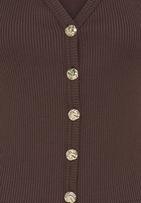 Tissu côtelé brun foncé avec six boutons argentés brillants de forme irrégulière disposés verticalement sur un vêtement à col en V.