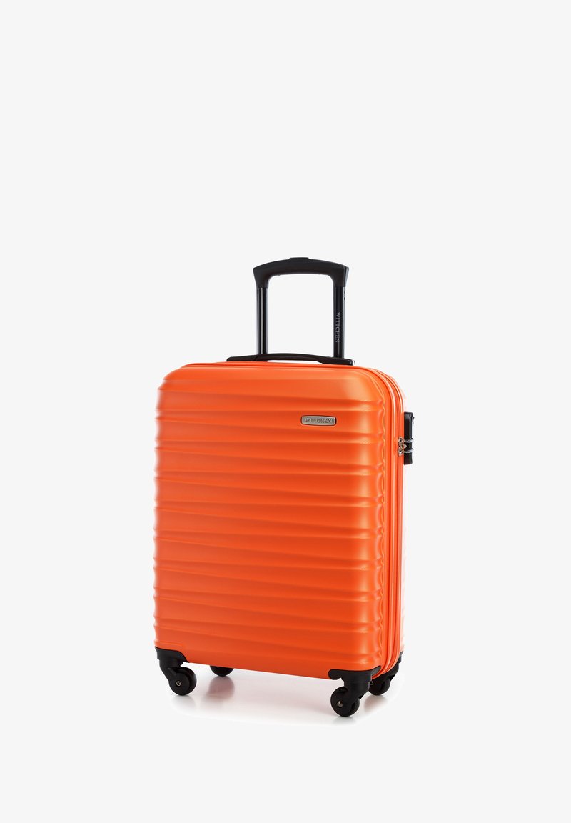Oranžový tvrdý kufr s rýhovaným povrchem, skládací černá rukojeť a čtyři černá kola pro snadnou manipulaci. Zapínání na zip a detail loga.
