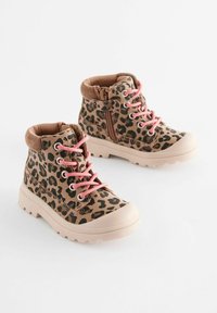 Bottines chelsea en imprimé léopard marron et noir, avec des lacets roses, un col rembourré et une semelle en caoutchouc texturé pour une bonne traction.