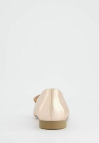 Nude ballerinat kengät sileästä satiinista, pyöreällä kärjellä ja matalalla, neliömäisellä korolla. Sisältää sauman takana yksityiskohtana.