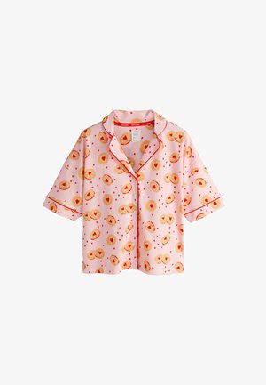 Trumpomis rankovėmis rožinė pižamos palaidinė su raudonais apvadais, ant audinio matomas raštas iš aukso spalvos pyragaičių ir raudonų širdelių.