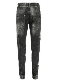 Joggers en denim noir avec une taille élastique, quatre poches et des poches latérales de style cargo. Texture usée avec un léger délavage.