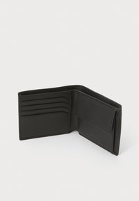 Portafoglio in pelle nera con più slot per carte e tasca per monete; texture liscia; design minimalista; l'interno presenta bordi cuciti e logo impresso.