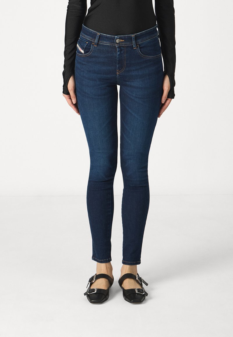 Ciemnoniebieskie dżinsy skinny wykonane z denimu, z klasycznym pięciopocketowym wzorem, kontrastowym przeszyciem i zapięciem na guziki z przodu.