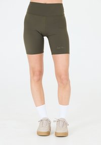 Shorts de vélo taille haute vert olive avec une texture lisse et des coutures piquées, arborant un logo subtil "Les’Arcs" sur la cuisse.