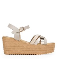 Sandale compensée en cuir beige clair avec texture crocodile et accents métalliques. Présente un design à large bride et une semelle texturée ressemblant à du liège.