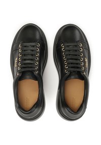 Des baskets en cuir noir présentent une texture lisse, un bout rond, des œillets dorés et des semelles intérieures contrastées marron. Côtés simples avec un minimum de marquage.