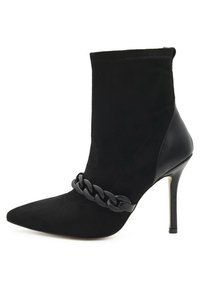 Stivale alla caviglia nero con punta affilata, realizzato in suede e pelle. Presenta un dettaglio a catena sul collo del piede e un tacco a spillo.