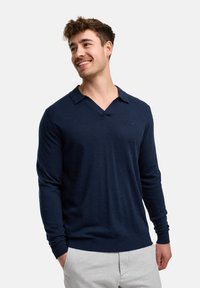 Herren Pullover aus navyblauem Strick mit V-Ausschnitt und Kragen. Lange Ärmel mit gerippten Bündchen und Saum; verfügt über ein kleines Logo auf der Brust.