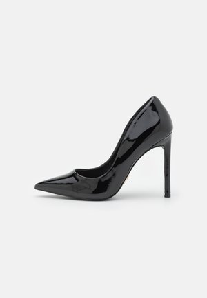 Sort laklæder højhælet pumpe med spids tå og slank stiletthæl vist i profil på hvid baggrund.