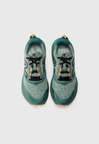 Green and black athletic shoes with a mesh upper, textured pattern, black laces, and gold hardware, featuring a cushioned sole and tab accents.