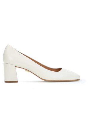 Hvid læder-sko med blokhæl, rundet tådesign og glat tekstur, der har en diskret tanfarvet inderside og en gulddetalje nær hælen.